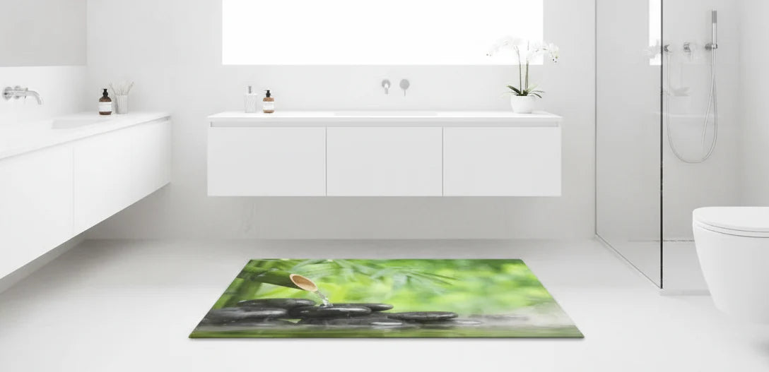 Salle de bain ultra lumineuse intégralement blanche, mettant en valeur un tapis zen vert à motif galets et bambou, pour une ambiance fraîche et élégante, collection idéale design premium.